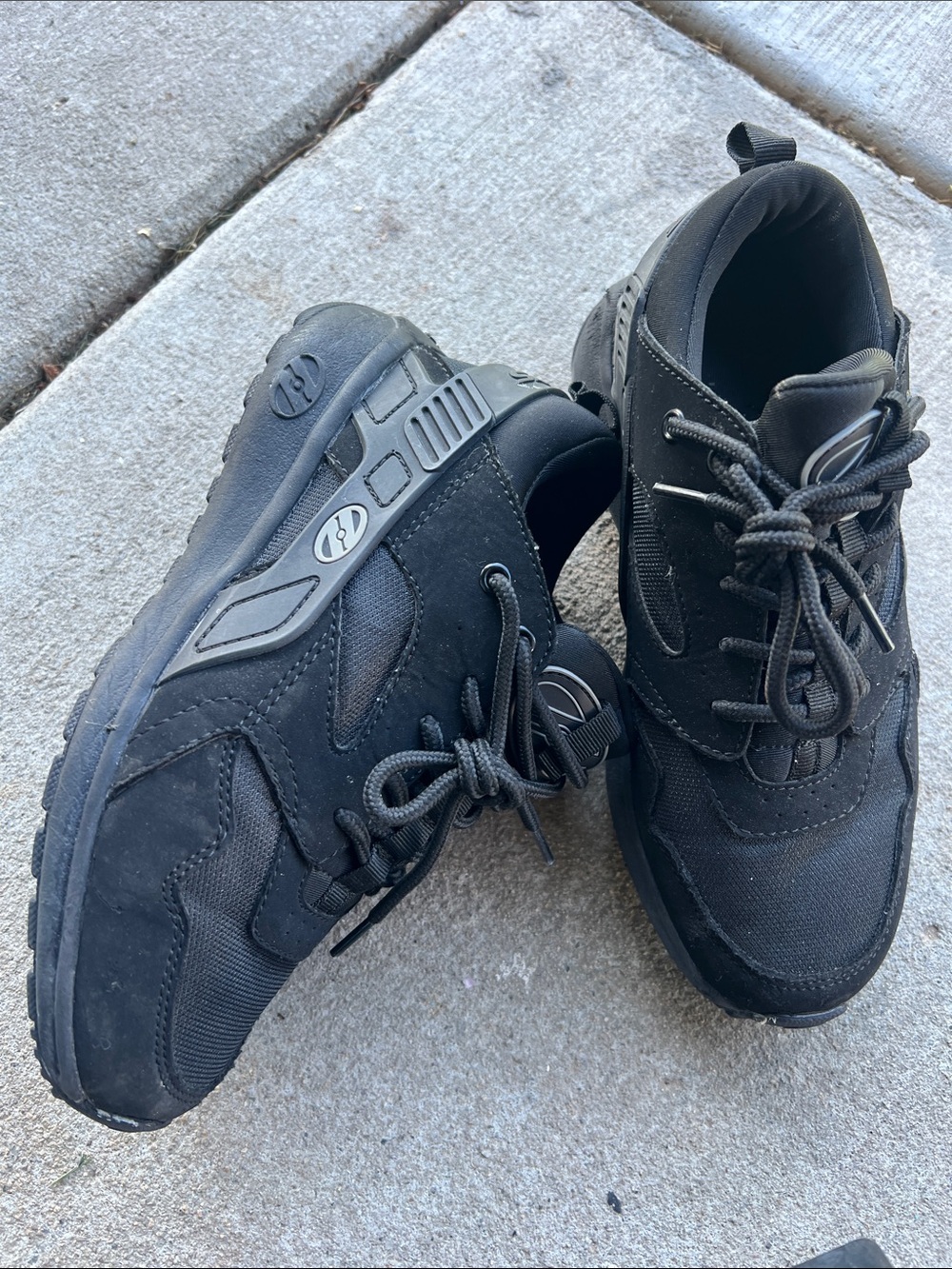 Black Heelys Force feature a wheel integrated into the heel for gliding.